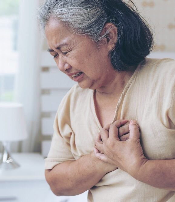 Senior woman experiencing irregular heartbeat symptoms, emphasizing the need for Arrhythmia Treatment in Indore by Dr. Akhilesh Jain.